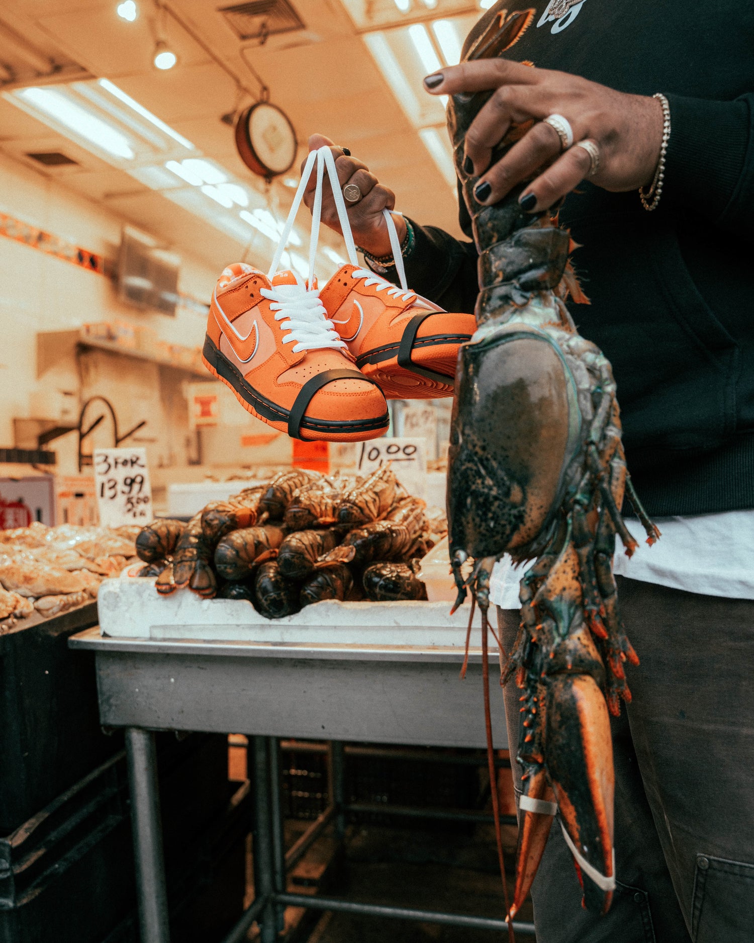 Calzado naranja junto a una langosta en una composición de mercado. Archivo visual de Kaleb Ramiu.